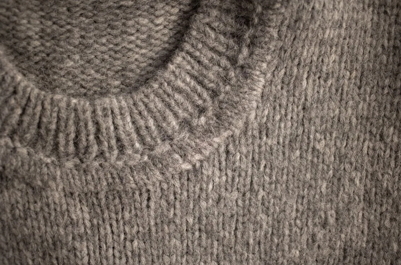 Pull en laine plié sur une table en bois