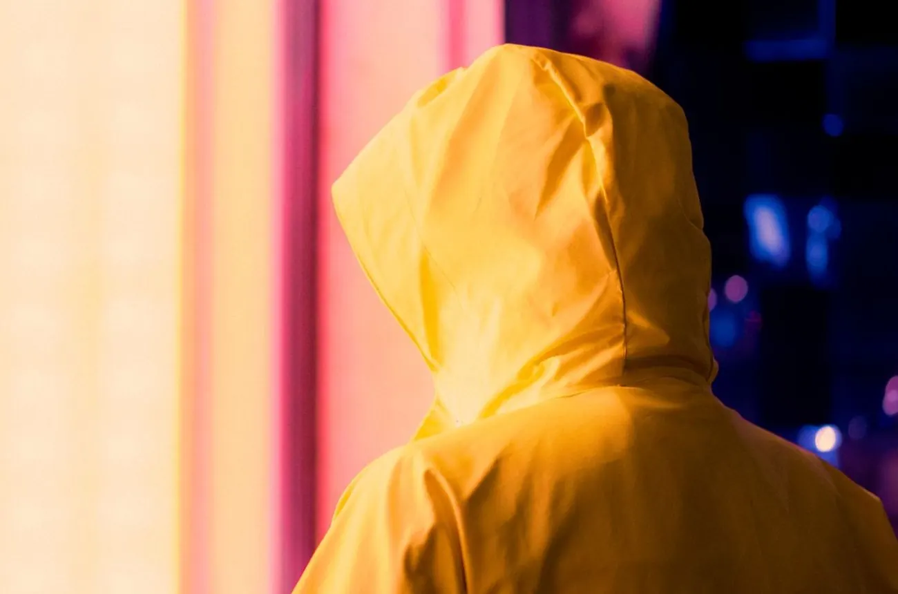 Silhouette de dos en veste imperméable jaune à capuche