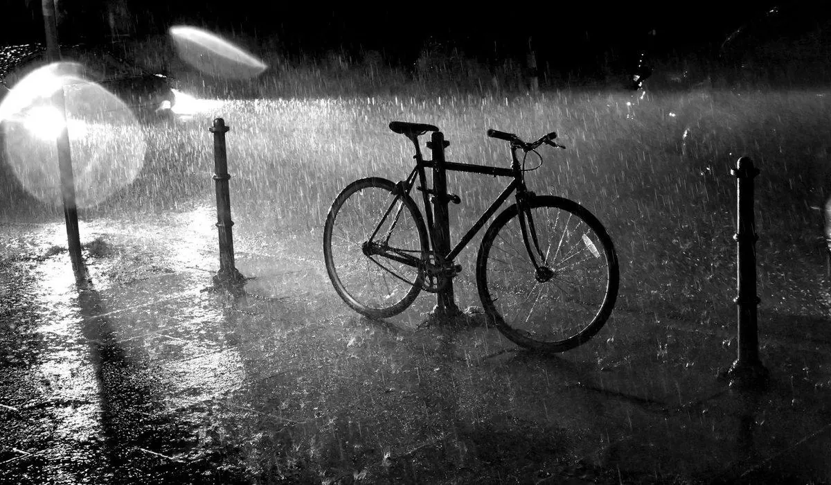 Vélo de ville garé sous une pluie battante