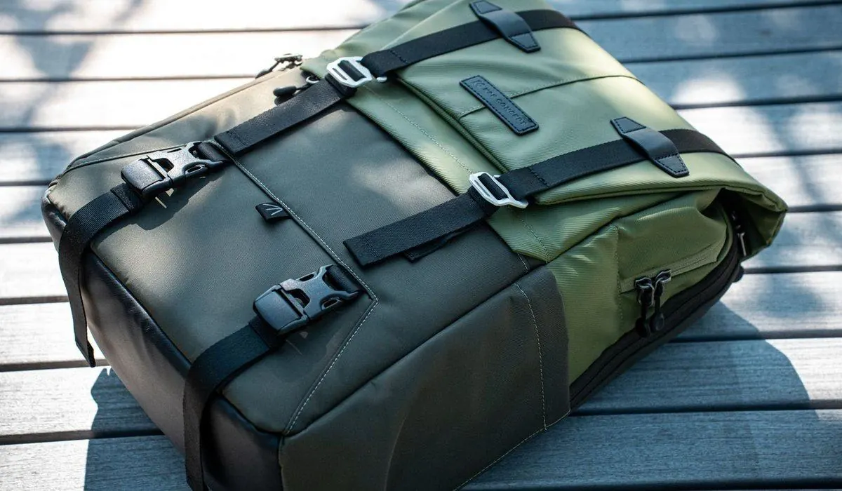 Khaki backpack closed with buckles, resting on a bench